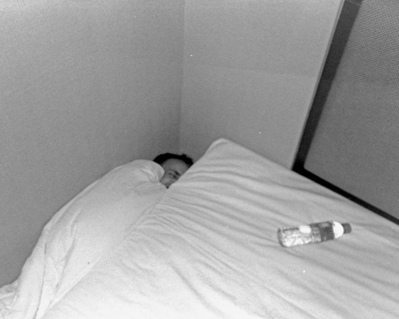 man down by bed black and white